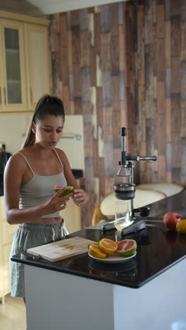 mujer haciendo jugo de fruta en la cocina
