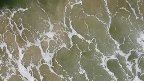 aerial view of ocean waves crashing on the shore