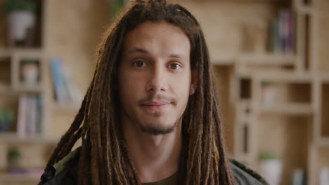 portrait of young man student looking serious mixed race male with dreadlocks hairstyle modern indoors background