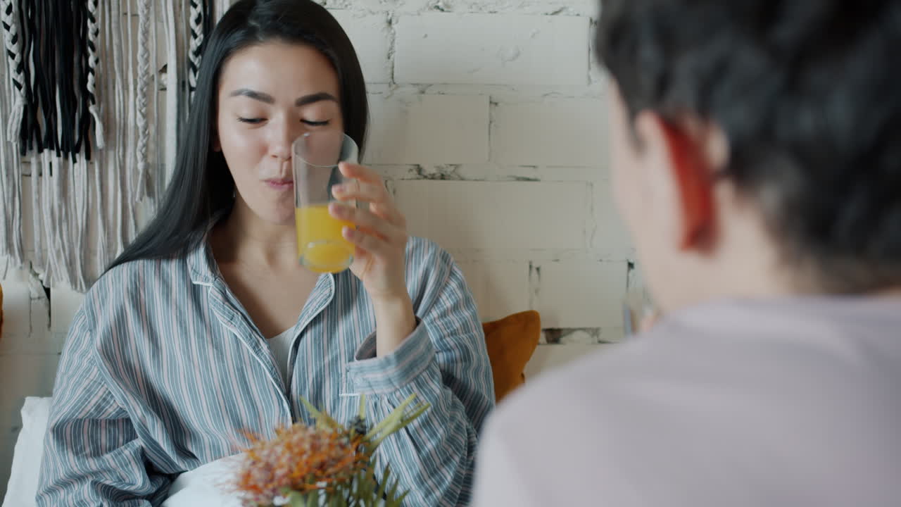 친구 들 이 침대 에서 아침 식사를 즐기고 있다