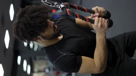 Young-man-exercising-on-multi-station-at-gym,-slow-motion