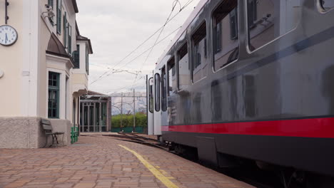 empty metro tram station with grey and red line with benches