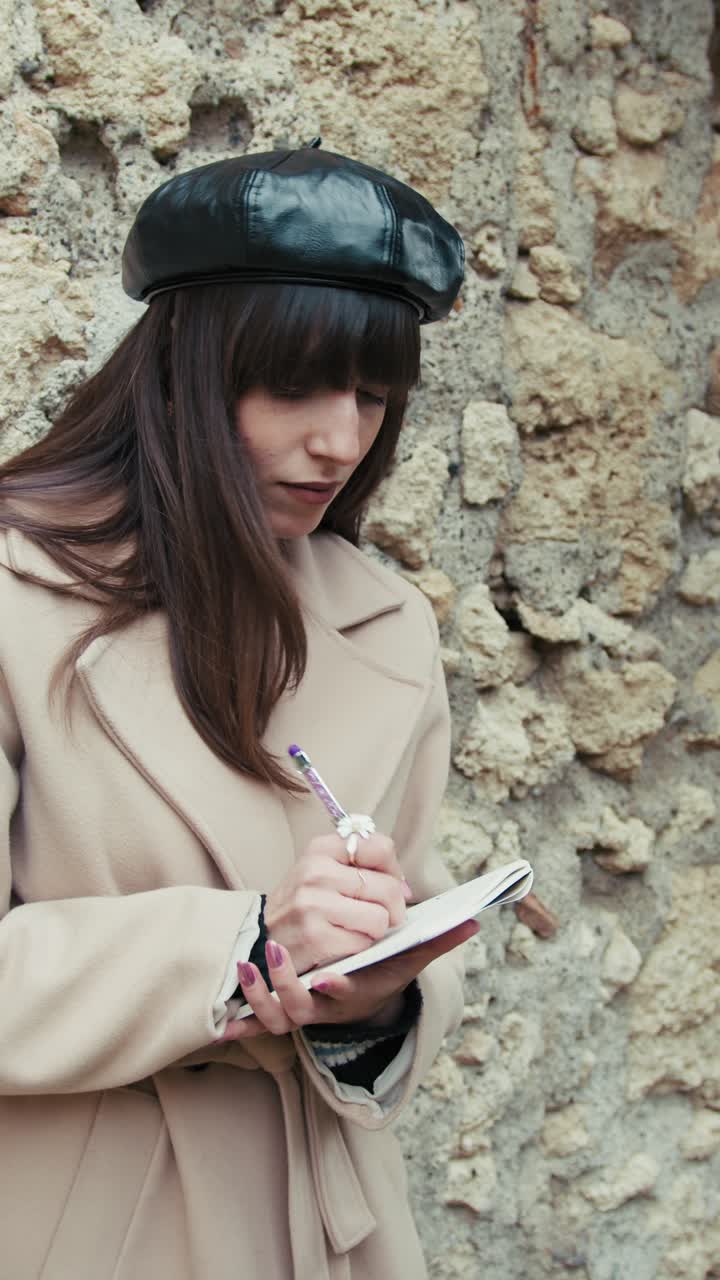 Woman Studying Outdoor In Her Little Hamlet While Leaning On A Wall