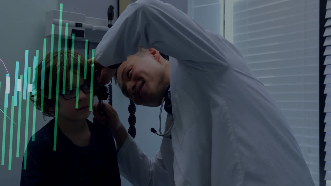 male doctor leaning over seated boy, examining ear with otoscope in health tech with floating icons