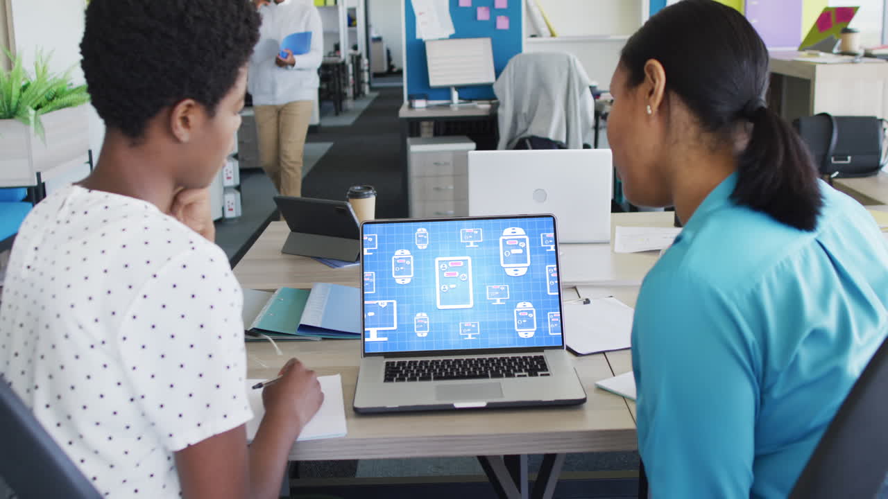 Diverse business people using laptop with digital chat on screen in office