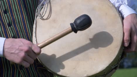 latvian boy in folk costume drumming in slow motion