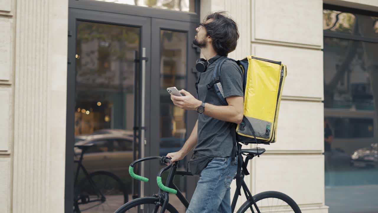 Delivery man who is going and texting on the smartphone