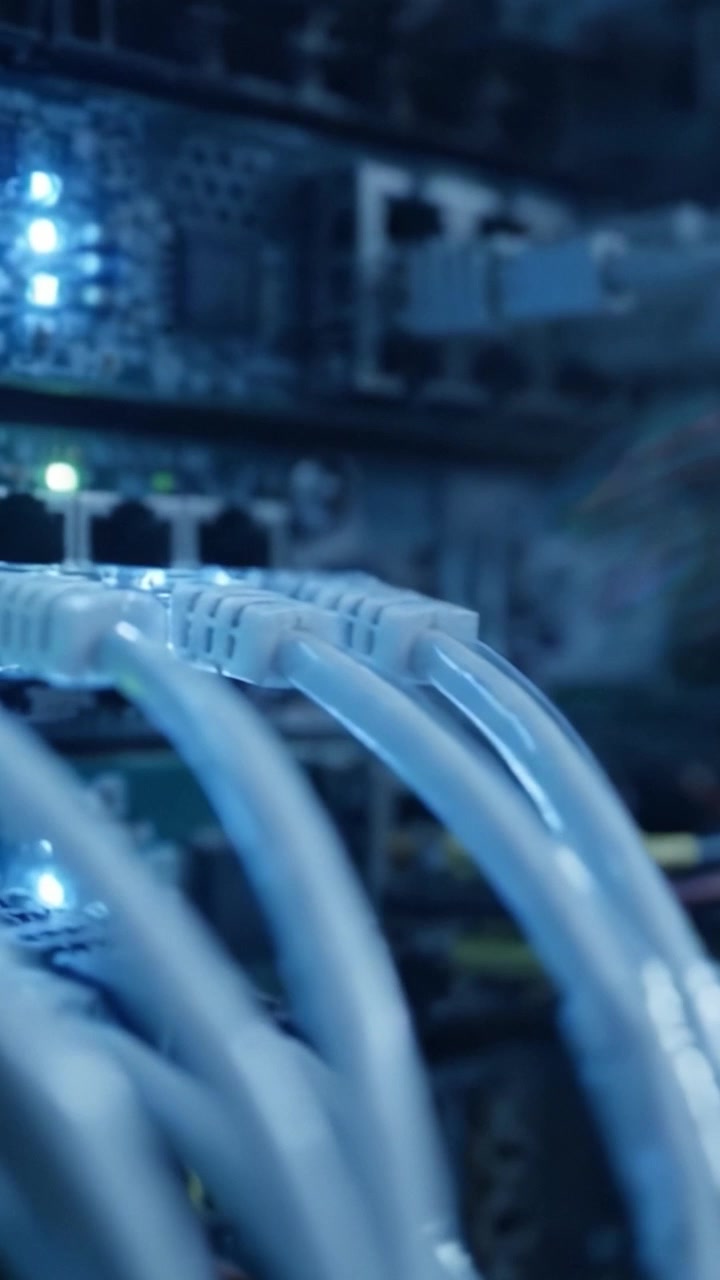 Un primo piano di cablaggio di rete ad alta tecnologia e componenti server, con porte illuminate e cavi di trasmissione dati in un moderno ambiente di data center.