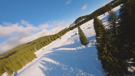 FPV-drone-shot-captured-in-Slovenia-in-Pokljuka-forest-with-surrounding-nature-and-mountains-at-golden-hour-at-sunset-with-fast-and-cinematic-movement-around-the-village-and-forest