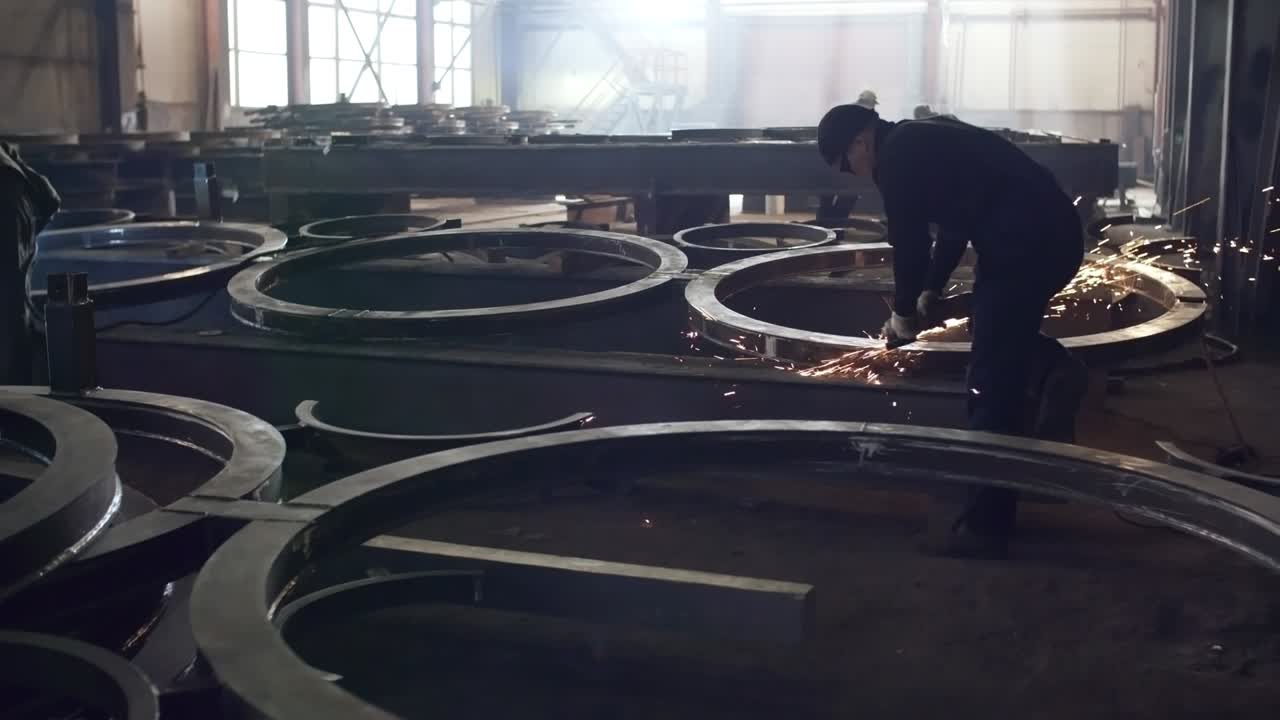 trabajadores de la fábrica de acero que pulen piezas metálicas