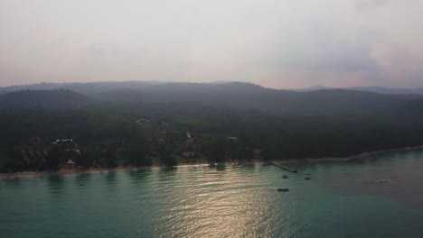 Tropical-Koh-Kood-beach-with-bungalows-and-calm-sea-in-morning-haze