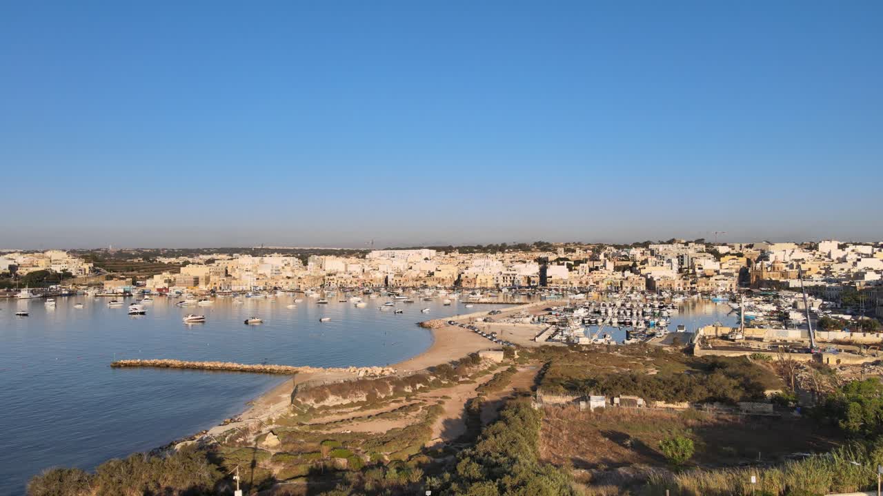 Vista aerea della baia di Marsaxlokk con barche da pesca e città sul lungomare a Malta