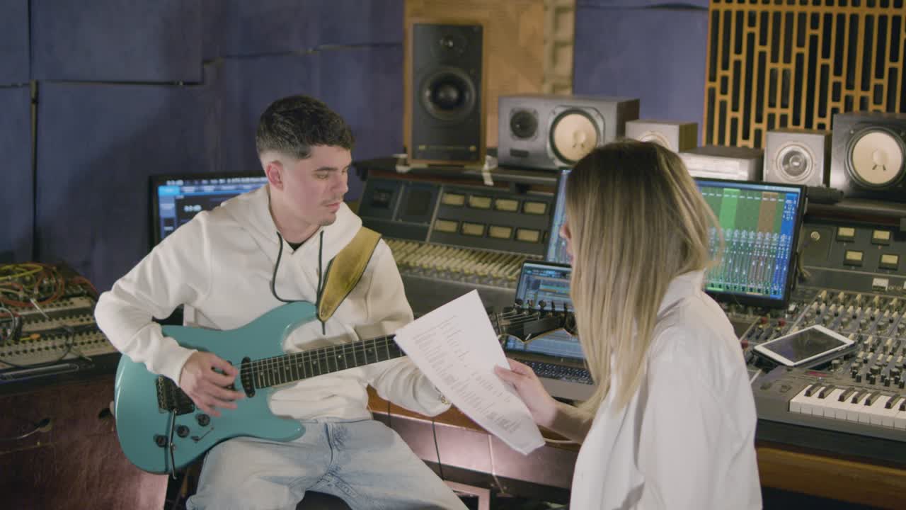 새로운 노래를 녹음하는 동안 음악 스튜디오에서 일하는 두 명의 음악가