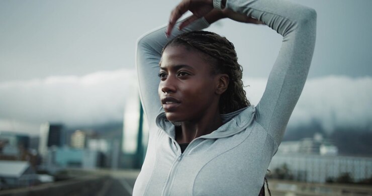 Young Woman Stretching Her Arms and Neck Outdoors in the City