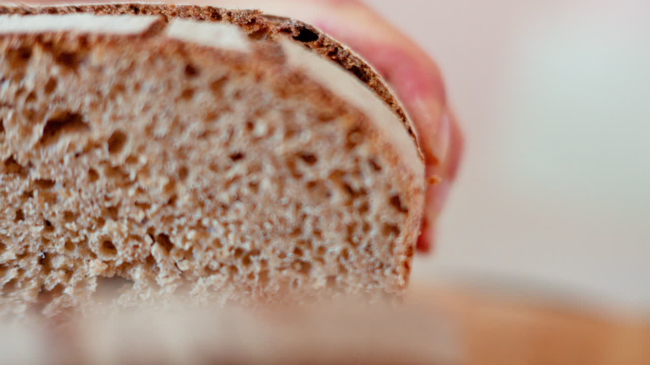 Woman cutting rye sourdough bread on a wooden cutting board