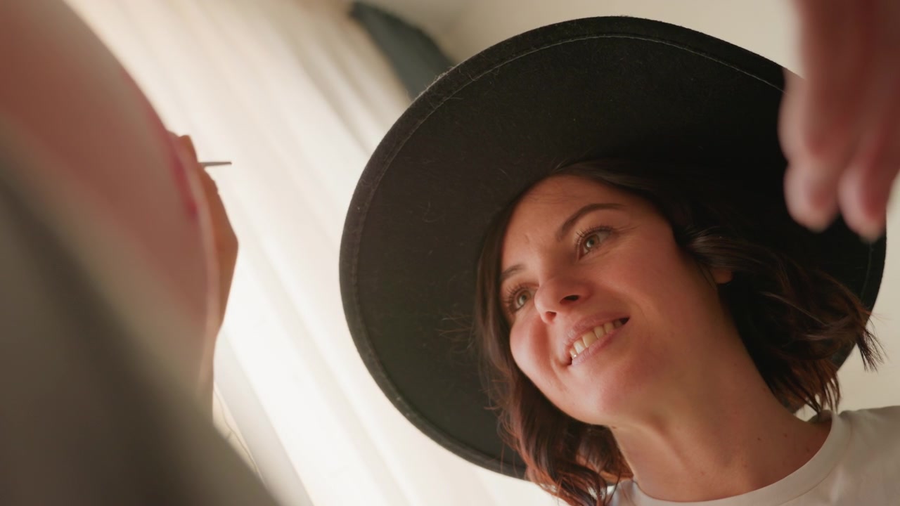 Donna creativa con un cappello che dipinge con un pennello