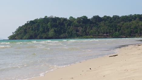 A-nice-tropical-paradise-shot-of-Koh-Kood-Island-in-Thailand,-shot-from-a-stunning-beach,-with-white-sand-and-waves-in-the-foreground-in-Southeast-Asia