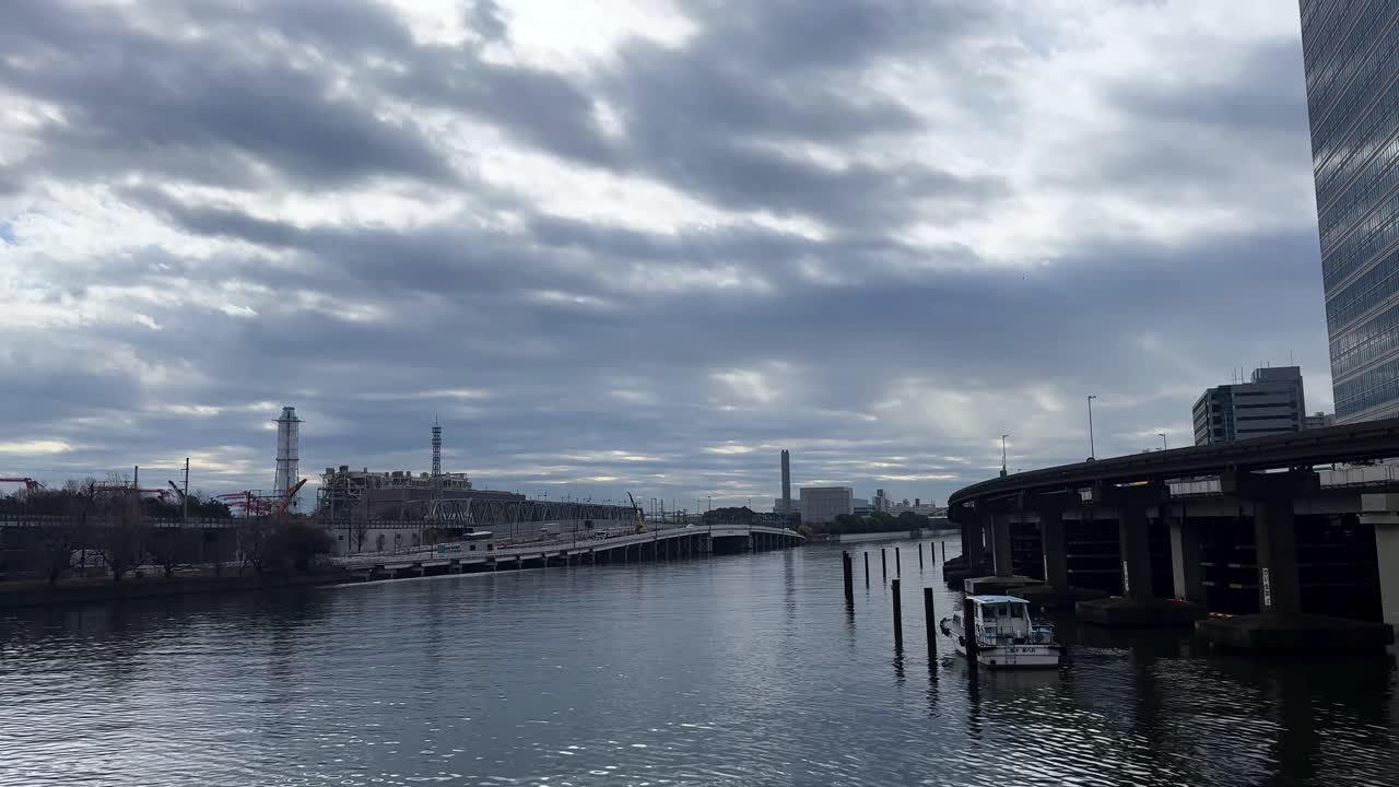A cloudy urban river view in Tokyo, Japan, showcasing calm water and cityscape