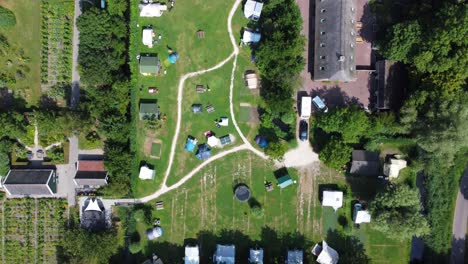 Vehicle-towing-a-caravan-through-the-entrance-of-holiday-park,-aerial