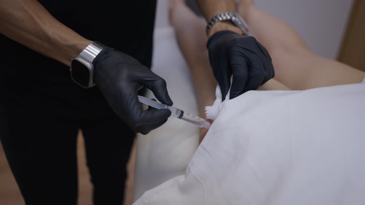 Medical professional administering an injection to a patient's leg