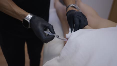 medical professional administering an injection to a patient's leg