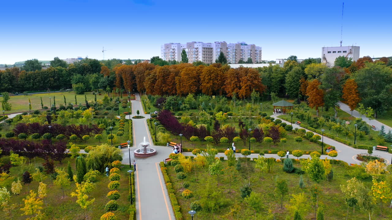 City park with beautiful architecture. Drone flying over the garden and then flying to residential area.