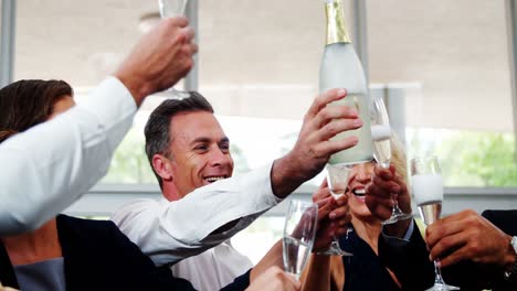 group of smiling friends toasting champagne glass