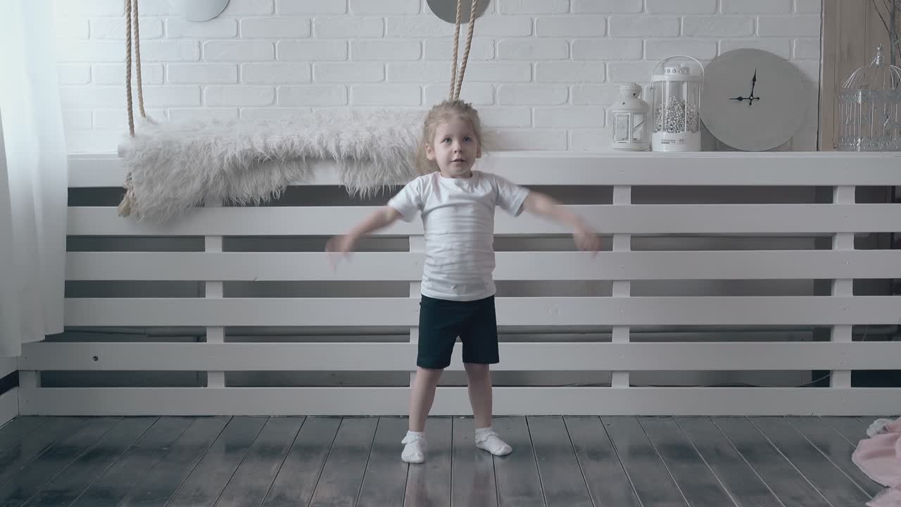 una bella bambina bionda con una maglietta bianca fa esercizi veloci