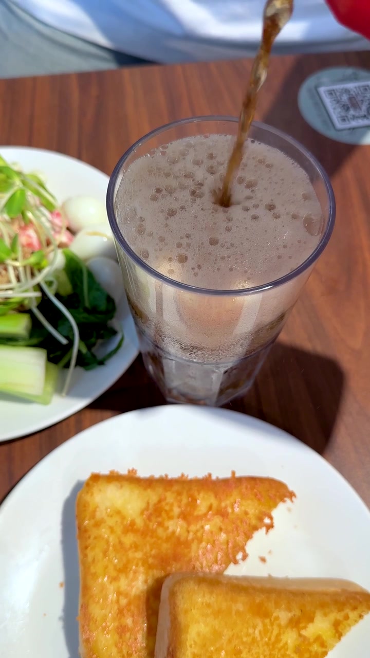 Vista superior de té helado vertido en un vaso junto a tostadas de camarones y ensalada fresca