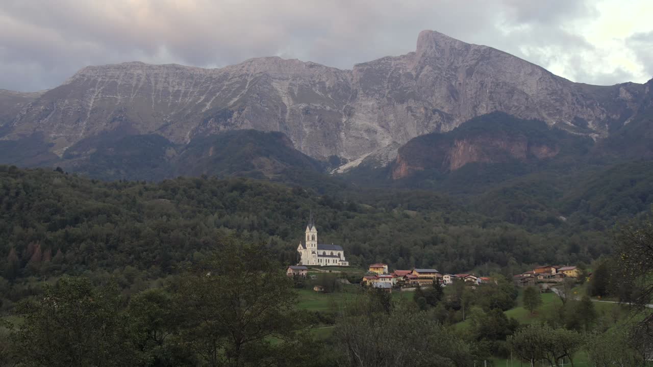Picturesque Village Nestled in the Alps with a Church and Mountain backdrop