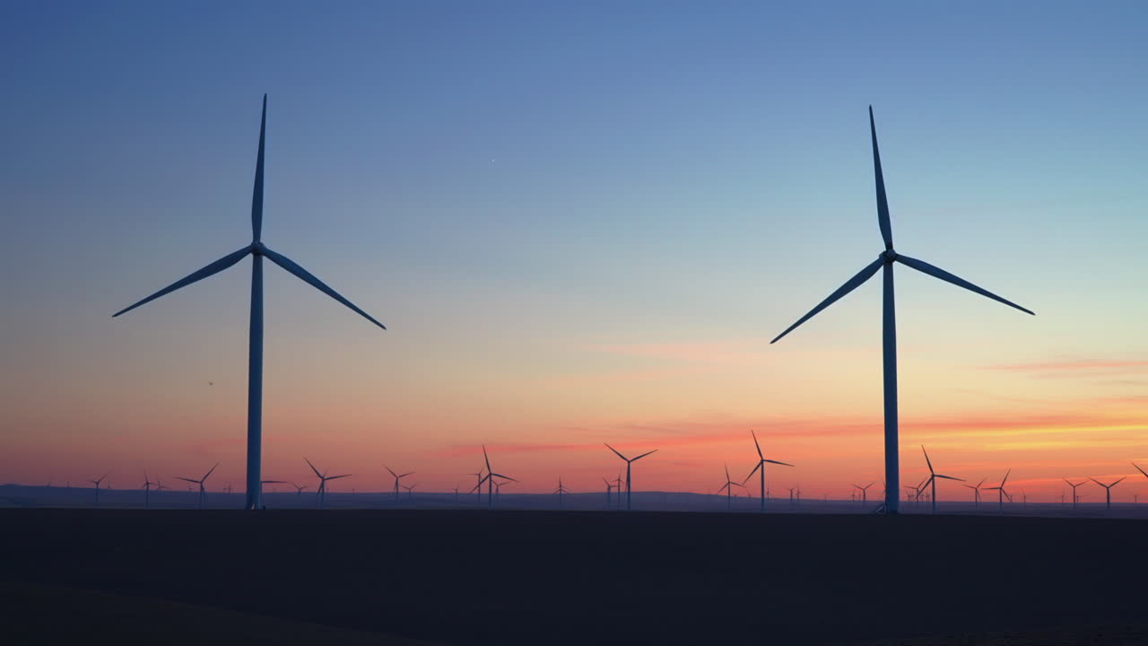 Silhouetted Wind Turbines At Work Against Vivid Sunset Sky. wide