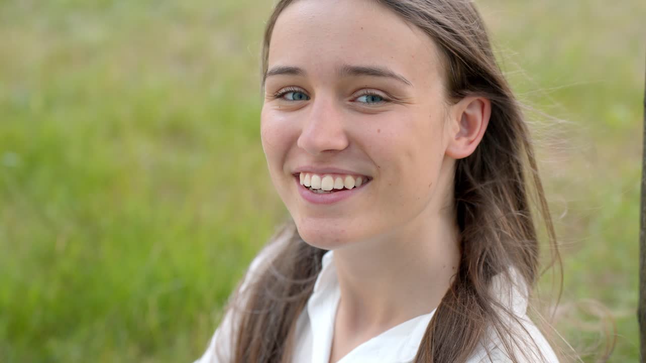 retrato en primer plano de una joven mujer caucásica sonriendo a la cámara