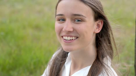 Close-up-portrait-of-young-Caucasian-woman-smiling-into-camera