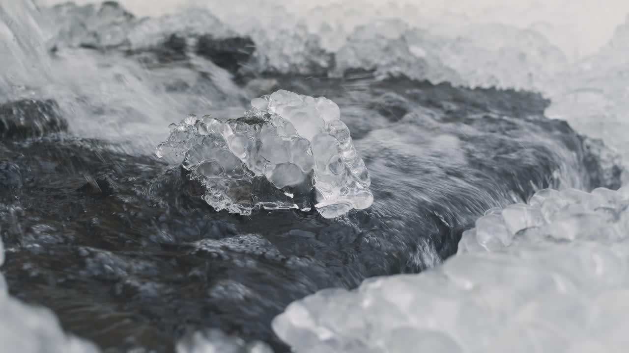vista de cerca del agua que cae de una pequeña cascada en un bosque nevado 2