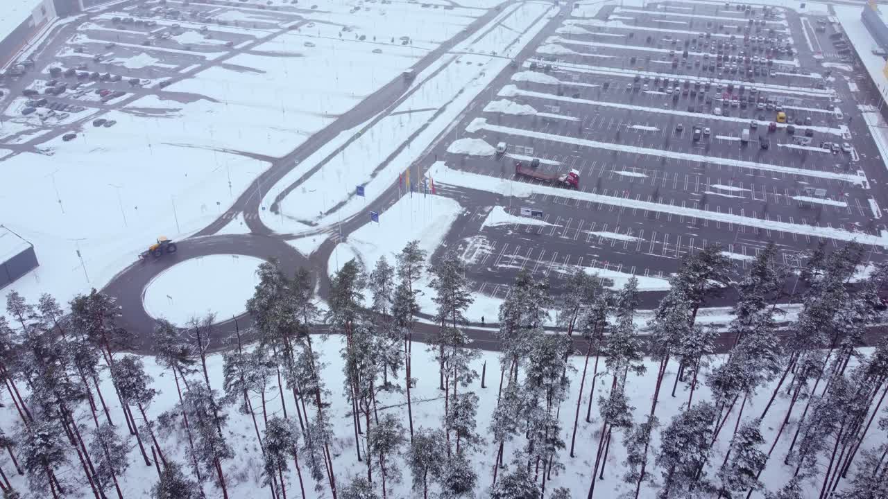 вид на автомобиль на кольцевой развязке и припаркованные автомобили на стоянке, зимнее время