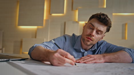 creative engineer analysing blueprint in engineering company office close up.