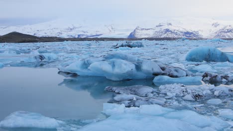 A-beautiful,-bluish-white-iceberg-floating-in-a-lake-in-Iceland---wide-shot