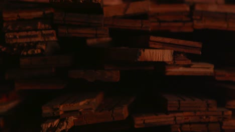 pan a la derecha a través de tablones de madera apilados en un taller