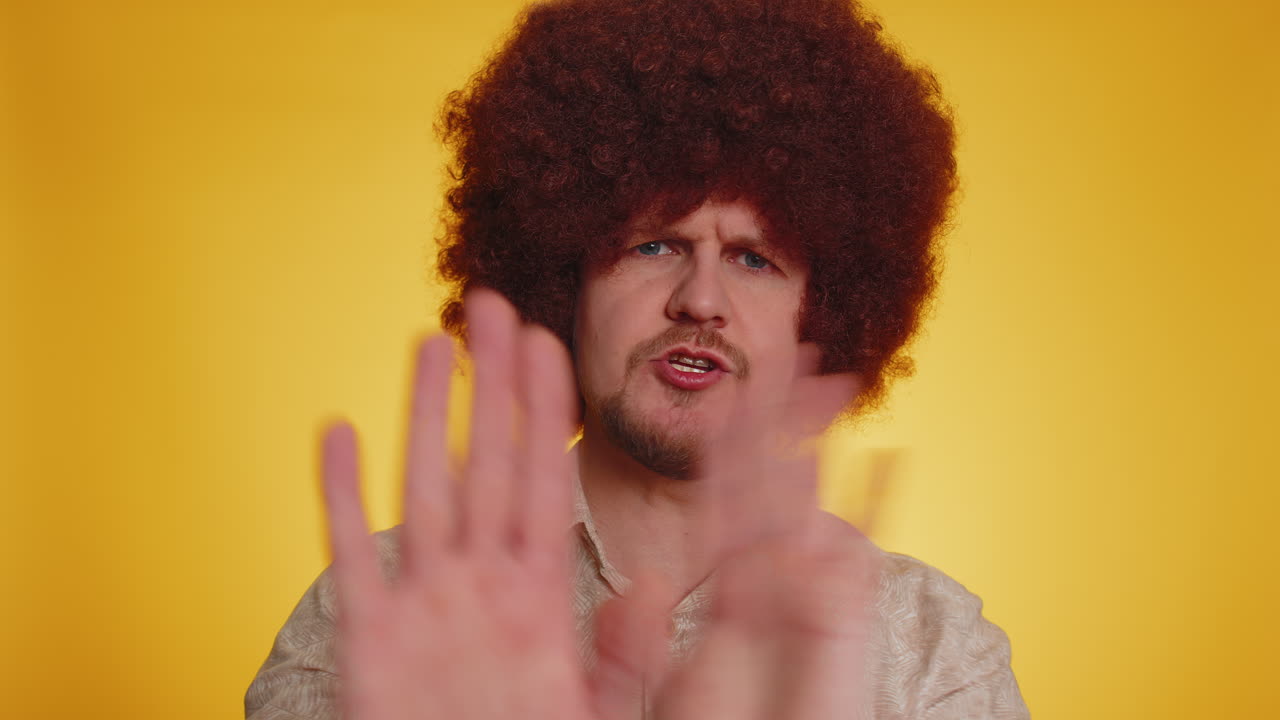 짜증나는 젊은 남자가 귀를 가리고 몸짓을 하고 조언을 피하지 않고 불쾌한 소음을 무시하고 큰 목소리를 내고