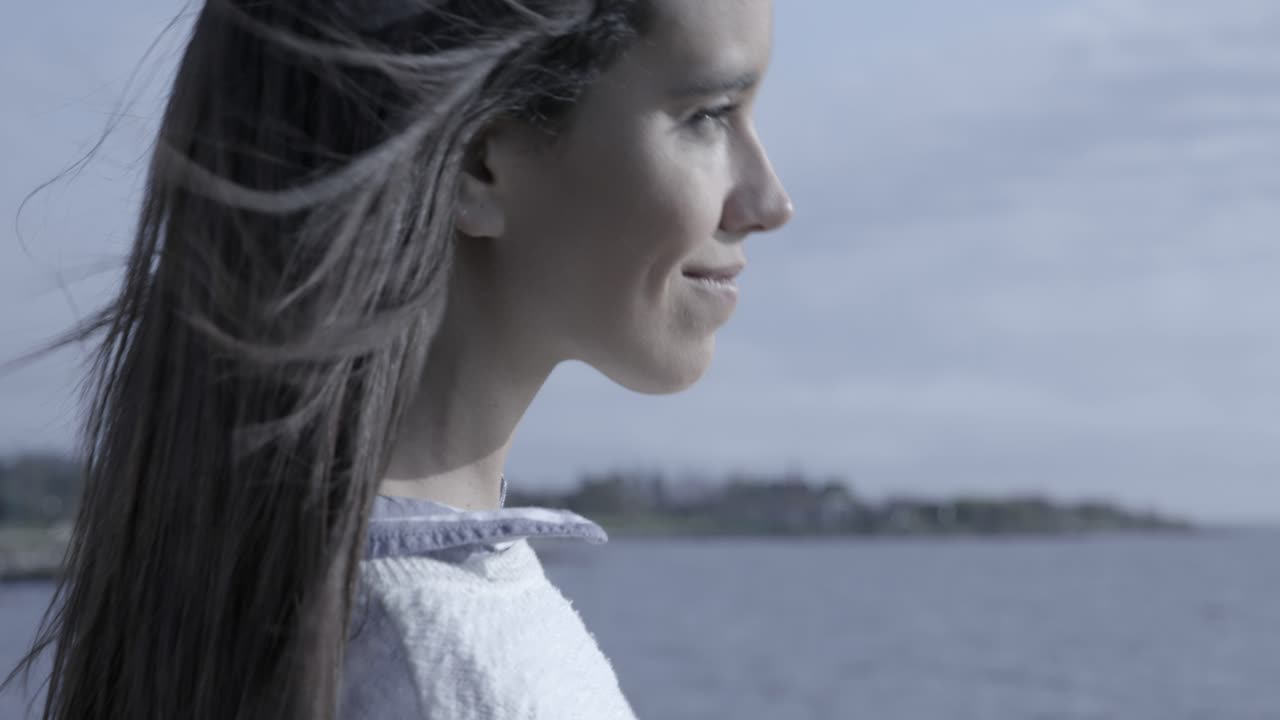 Donna felice con i capelli al vento vicino all'oceano