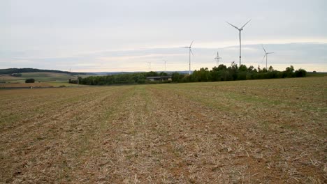 Tren-Eléctrico-De-Pasajeros-De-Alta-Velocidad-Que-Pasa-Por-Un-Valle-Verde-Con-Molinos-De-Viento