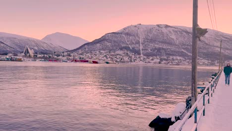 Weitwinkelschwenk,-Beginnend-Auf-Der-Brücke-Und-Dann-Hinüber-Zu-Gebäuden-In-Tromsø,-Norwegen,-Mit-Schneebedeckten-Bergen-In-Der-Ferne