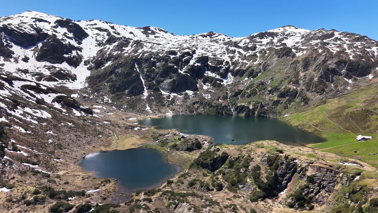 Murgsee lake in Switzerland with snowy mountains on a clear day, highlighting the natural beauty of the Swiss Alps, for adventure travel and relax, drone pulling out