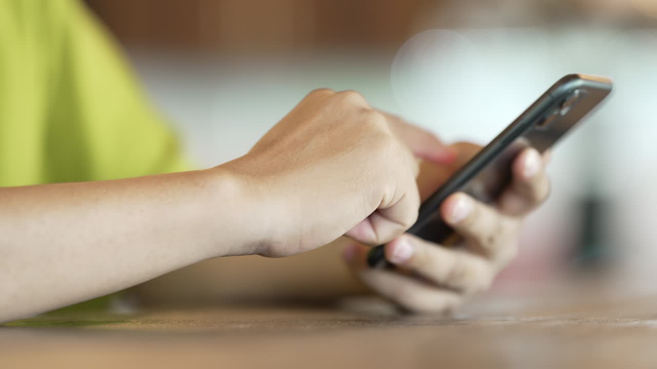 close up man checking email with cell phone at a coffee shop
