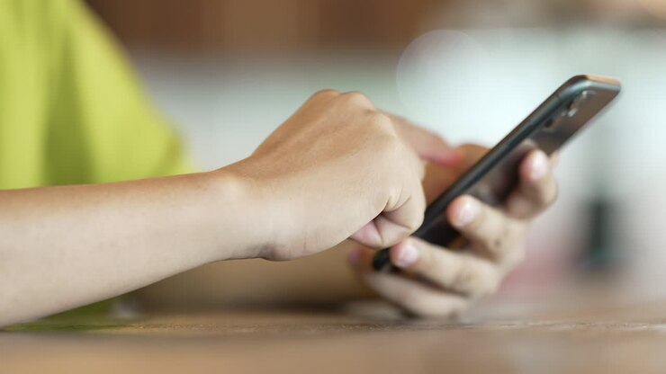 close up man checking email with cell phone at a coffee shop