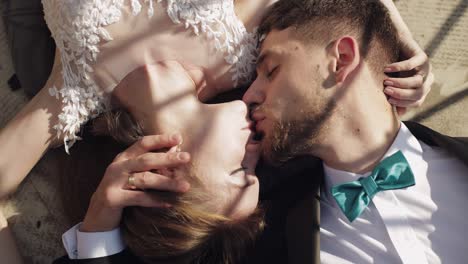 newlyweds. caucasian groom with bride lie on the ground next to each other