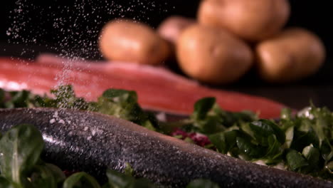 Fresh-whole-trout-on-a-bed-of-leaves-being-seasoned