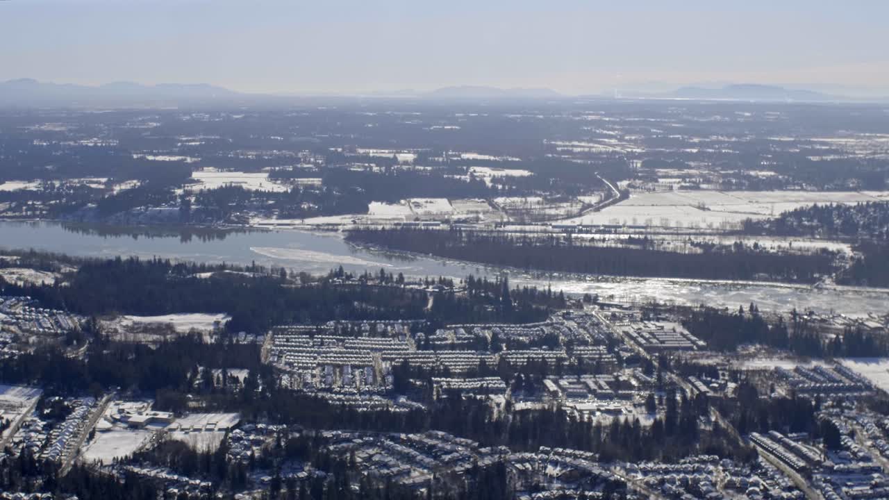 A Winter View of a Snowy Suburban Landscape With the Fraser River Winding Through, Surrey, British Columbia, Canada - Aerial Drone Shot