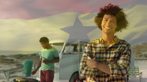 animation of waving ghana flag over group of diverse friends on the beach