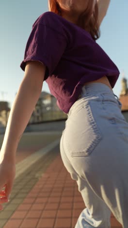 woman in purple shirt and light blue jeans on rooftop